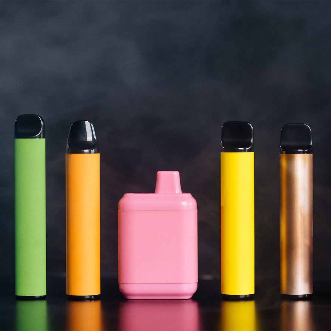 row of disposable vapes on black background
