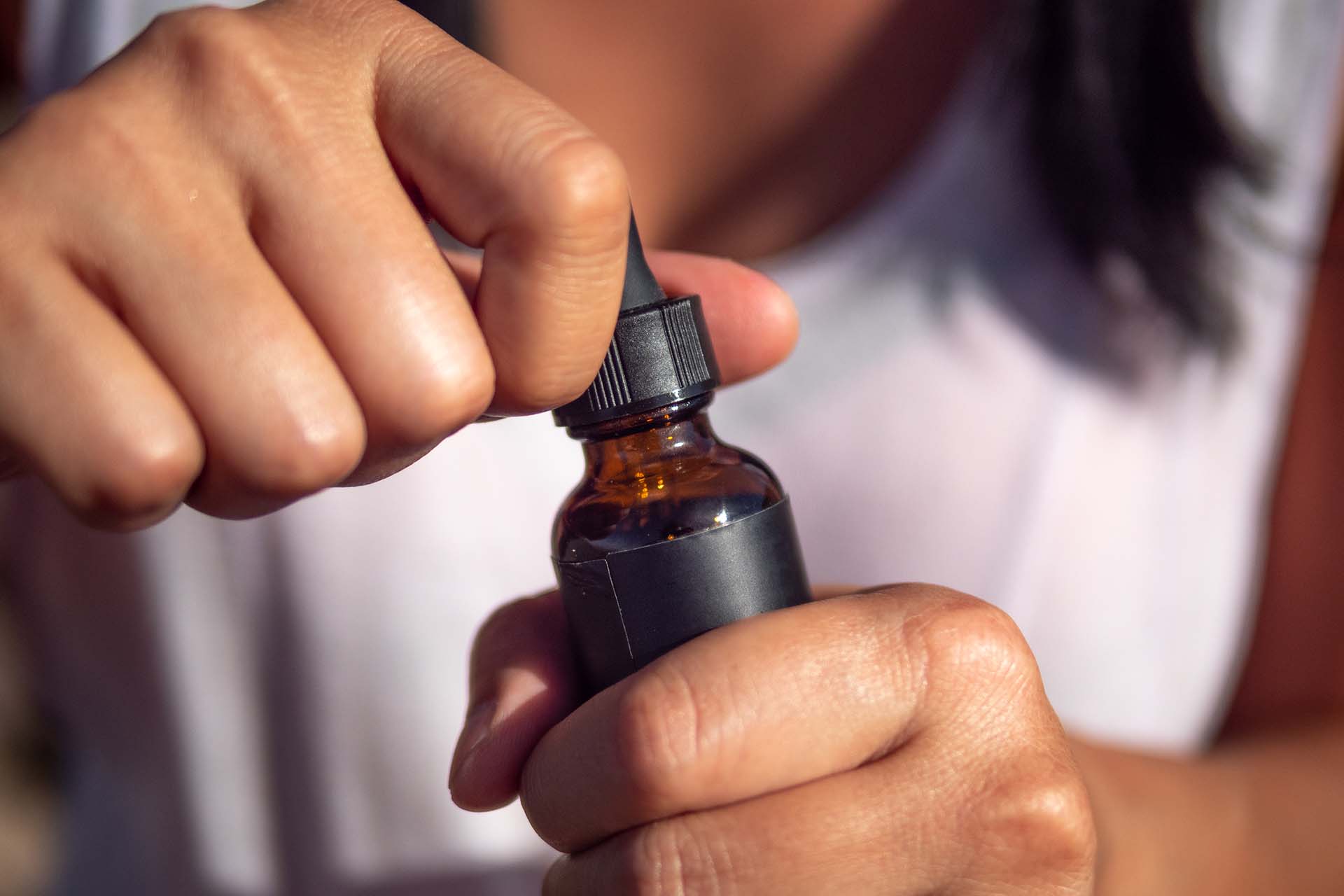 person holding a bottle of CBD oral drops (image)