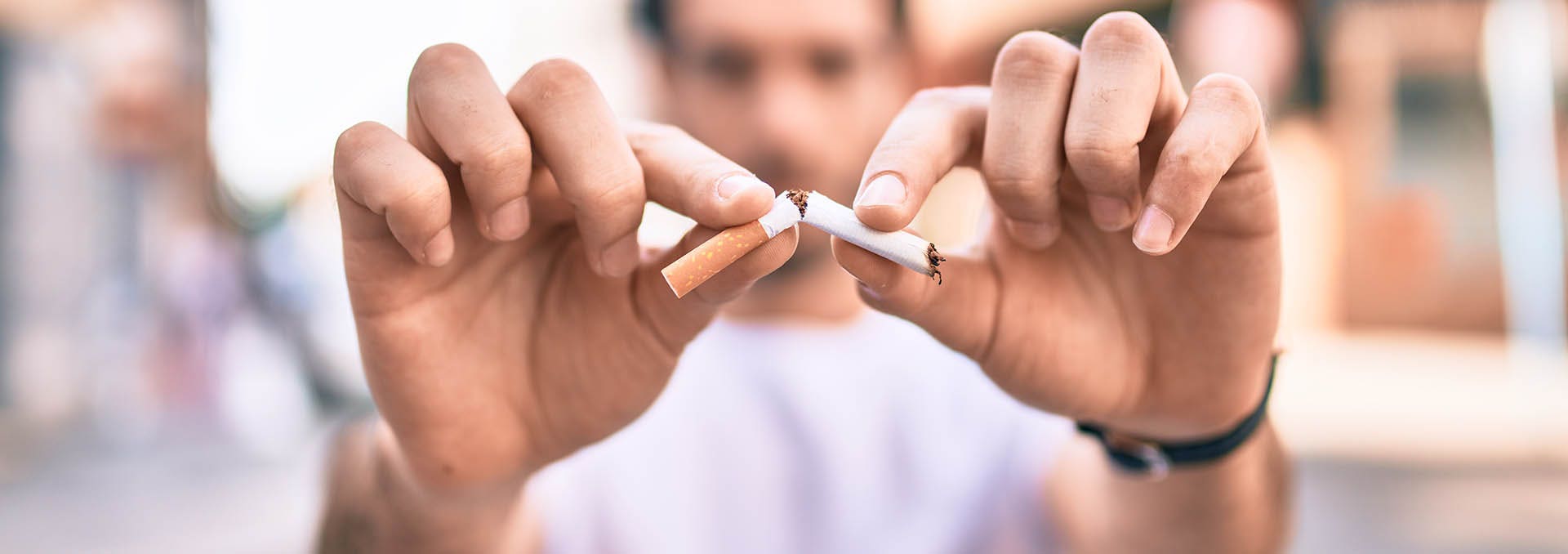 Man snapping a cigarette in half (Image)