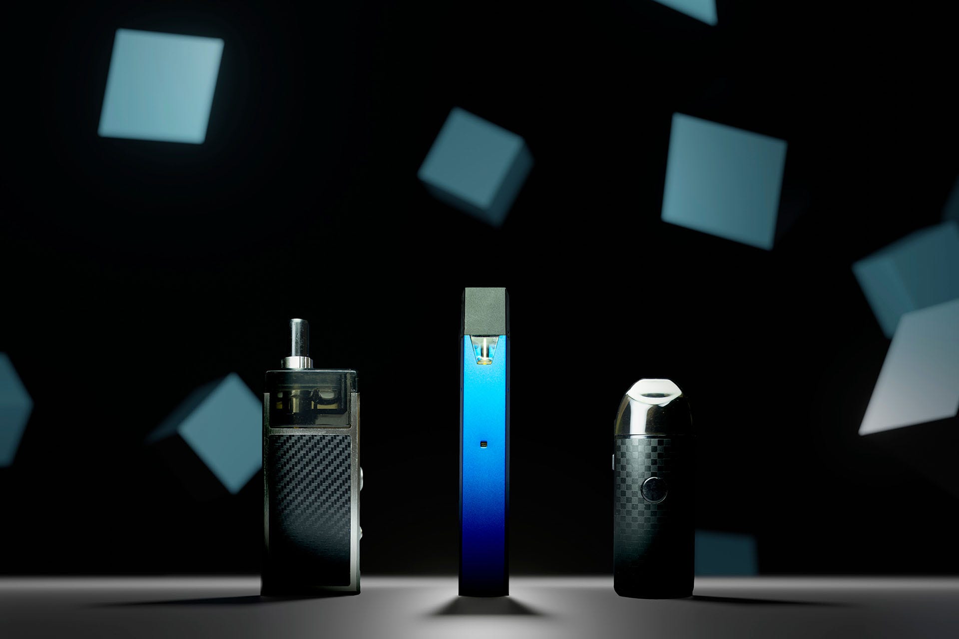 Several pod vape kits stood up on a dark background(Image)