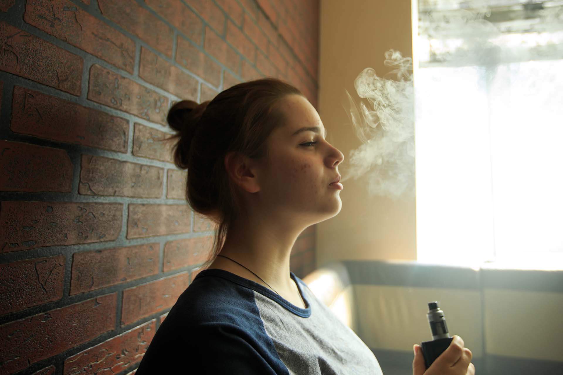 Woman blowing out vapour from a vape kit (Image)